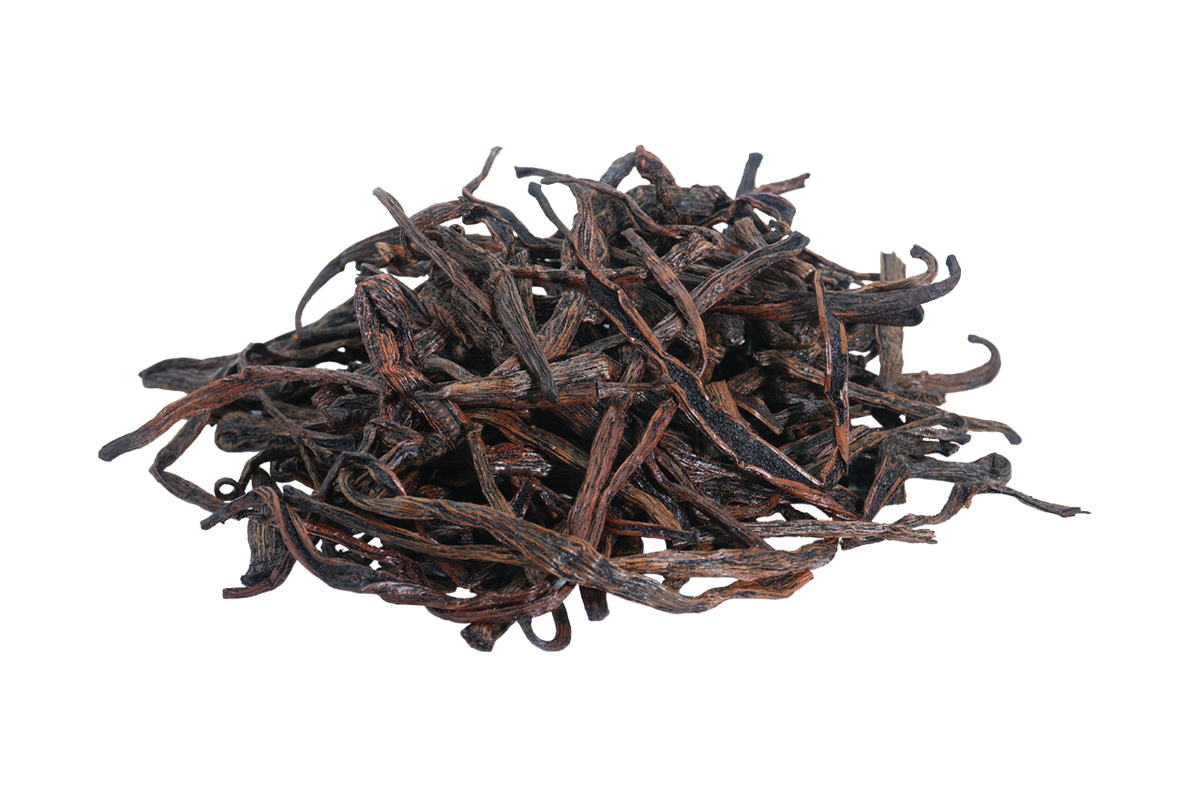 Pile of loose Madagascar Bourbon vanilla beans and cut pieces, showing their natural dark brown color and dried texture.