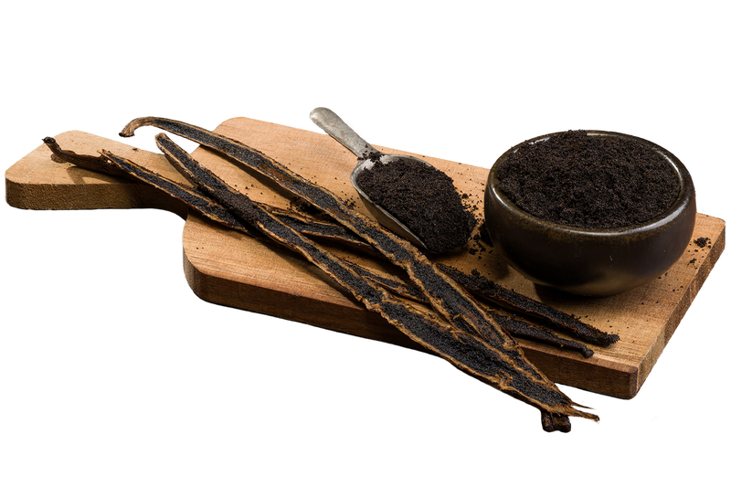 Madagascar Bourbon vanilla caviar in a bowl and spoon, surrounded by split vanilla beans on a wooden board.